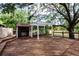 Large wooden deck featuring pergola, built-in benches, outdoor kitchen, and lush surroundings at 17358 Hwy 27, Clermont, FL 34715