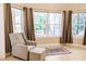 A comfortable sitting room featuring a large window with a lush, landscaped view and a neutral color palette at 17358 Hwy 27, Clermont, FL 34715