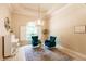 Bright sitting room featuring a chandelier, shuttered windows, and two plush velvet chairs at 17358 Hwy 27, Clermont, FL 34715