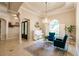 Bright sitting room featuring a chandelier, shuttered windows, and two plush velvet chairs at 17358 Hwy 27, Clermont, FL 34715
