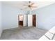 Light-filled main bedroom with neutral paint, ceiling fan, and doorways leading to the bathroom and closet at 9582 Sw 70Th Loop, Ocala, FL 34481
