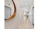 Bright hallway with tile flooring, multiple doors, and an elegant circular mirror on the wall at 3120 Paradox Cir # 307, Kissimmee, FL 34746