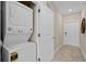 Hallway with stackable washing machine and dryer situated near a closet and hallway entrance at 3120 Paradox Cir # 307, Kissimmee, FL 34746