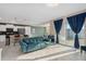 Bright, open-concept living area with a blue sofa, kitchen island, and sliding glass doors at 3120 Paradox Cir # 307, Kissimmee, FL 34746