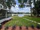 Beautiful backyard with lush lawn, lake view, landscaping and a screened-in lanai at 3610 Pershing Ave, Orlando, FL 32812