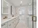 Modern bathroom featuring double vanity, elegant mirrors, and a glass-enclosed shower at 3610 Pershing Ave, Orlando, FL 32812