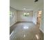 Bright bedroom with terrazzo flooring, two windows, and a walk-in closet at 3610 Pershing Ave, Orlando, FL 32812