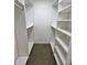 Walk-in closet with custom white shelving and storage with speckled flooring at 3610 Pershing Ave, Orlando, FL 32812