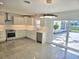 Modern kitchen with island, stainless steel appliances, and sliding doors to outside at 3610 Pershing Ave, Orlando, FL 32812