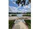 Beautiful lake view showing a walkway leading down to the water, set beneath a blue, cloudy sky at 3610 Pershing Ave, Orlando, FL 32812