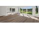 Sun-filled living room with wood floors and large windows overlooking landscaped yard and pond at 3610 Pershing Ave, Orlando, FL 32812