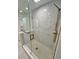 Modern glass shower with a rainfall shower head and marble-look tile at 3610 Pershing Ave, Orlando, FL 32812
