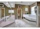 Beautiful bathroom featuring dual sinks, a soaking tub, and unique wood wall accents at 5810 Lake Victoria Dr, Lakeland, FL 33813