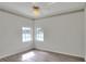 Bright bedroom with hardwood floors, ceiling fan, neutral paint, and natural light from the two windows at 5810 Lake Victoria Dr, Lakeland, FL 33813