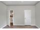 Bedroom features hardwood floors, neutral paint, ceiling fan, and access to the kitchen through a door at 5810 Lake Victoria Dr, Lakeland, FL 33813