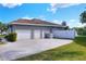 Home exterior with a three-car garage and a large paved driveway at 5810 Lake Victoria Dr, Lakeland, FL 33813
