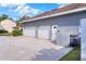 Three car garage featuring white doors, driveway, and an adjacent utility box at 5810 Lake Victoria Dr, Lakeland, FL 33813