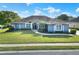 Beautiful one-story home with lush green lawn, manicured landscaping, and blue exterior at 5810 Lake Victoria Dr, Lakeland, FL 33813