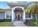 Inviting front porch with white pillars and a vibrant red door adorned with a festive wreath at 5810 Lake Victoria Dr, Lakeland, FL 33813