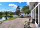 Paver patio with seating overlooking the lake, plus shade trees, and an adjacent screened-in porch at 5810 Lake Victoria Dr, Lakeland, FL 33813