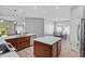 Open kitchen with wood cabinets, quartz countertops, stainless steel appliances, and connected dining area at 3657 Daydream Pl, St Cloud, FL 34772