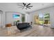 Living room with a ceiling fan, wood flooring, sofa and sliding glass door to backyard at 3657 Daydream Pl, St Cloud, FL 34772