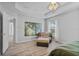 Relaxing main bedroom showcases modern light fixture, stylish chair, and wood-look floors at 3657 Daydream Pl, St Cloud, FL 34772