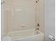 Shower-tub combination with a white tiled wall and metal showerhead at 3657 Daydream Pl, St Cloud, FL 34772