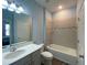 Bathroom featuring a shower over bath, light blue walls, and a white ceramic toilet and sink at 1142 Blarney St, Minneola, FL 34715