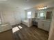 Well-lit bathroom features a tub, vanity with granite countertop, and wood-look floors at 1142 Blarney St, Minneola, FL 34715