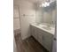Bathroom with a double sink vanity, modern fixtures, and white cabinets at 1142 Blarney St, Minneola, FL 34715