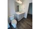 Bathroom featuring hard wood floors, a toilet, vanity, mirror and an entrance to another room at 1142 Blarney St, Minneola, FL 34715