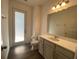 Bathroom featuring hard wood floors, a toilet, vanity, mirror and exterior entrance at 1142 Blarney St, Minneola, FL 34715