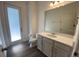 Bathroom featuring hard wood floors, a toilet, vanity, mirror and exterior entrance at 1142 Blarney St, Minneola, FL 34715