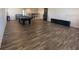 A spacious game room features sleek flooring and a pool table for entertainment, with natural lighting at 1142 Blarney St, Minneola, FL 34715