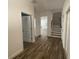 Hallway with Hardwood floors leading to staircase and showcasing doors and open views of the home's interior at 1142 Blarney St, Minneola, FL 34715