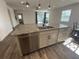 Modern kitchen island with stainless steel dishwasher, granite countertop, and sink at 1142 Blarney St, Minneola, FL 34715