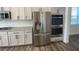 Stainless steel refrigerator and double oven surrounded by white cabinets and granite countertops at 1142 Blarney St, Minneola, FL 34715