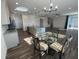 Modern kitchen with stainless appliances, large island, and adjacent dining area with a round glass table at 1142 Blarney St, Minneola, FL 34715