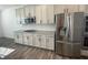 Gourmet kitchen features stainless steel appliances, white cabinetry, granite countertops, and wood floors at 1142 Blarney St, Minneola, FL 34715