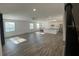 Open-concept living space with hardwood floors flowing into kitchen featuring an island and stainless steel appliances at 1142 Blarney St, Minneola, FL 34715