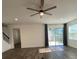Bright living room with ceiling fan, sliding glass doors, and stairs in the background at 1142 Blarney St, Minneola, FL 34715