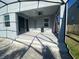Covered patio with steps down to yard and sliding door to the interior at 1142 Blarney St, Minneola, FL 34715