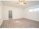 Bedroom features wood-look flooring, ceiling fan, and blue door at 1501 7Th Se St, Winter Haven, FL 33880