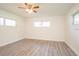Bright bedroom with light gray floors and a ceiling fan, illuminated by three windows at 1501 7Th Se St, Winter Haven, FL 33880