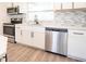 Updated kitchen with stainless steel appliances, white cabinetry, and modern backsplash at 1501 7Th Se St, Winter Haven, FL 33880