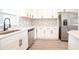 Modern kitchen with stainless steel appliances, white cabinets, and grey tile backsplash at 1501 7Th Se St, Winter Haven, FL 33880