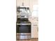 Stainless steel oven and microwave combo with white cabinets and grey tile backsplash at 1501 7Th Se St, Winter Haven, FL 33880