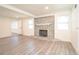 Open living room showcasing the brick fireplace, wood floors, and natural light from windows at 1501 7Th Se St, Winter Haven, FL 33880