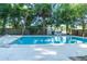 Large backyard pool surrounded by lush greenery and a wooden fence for privacy at 1501 7Th Se St, Winter Haven, FL 33880